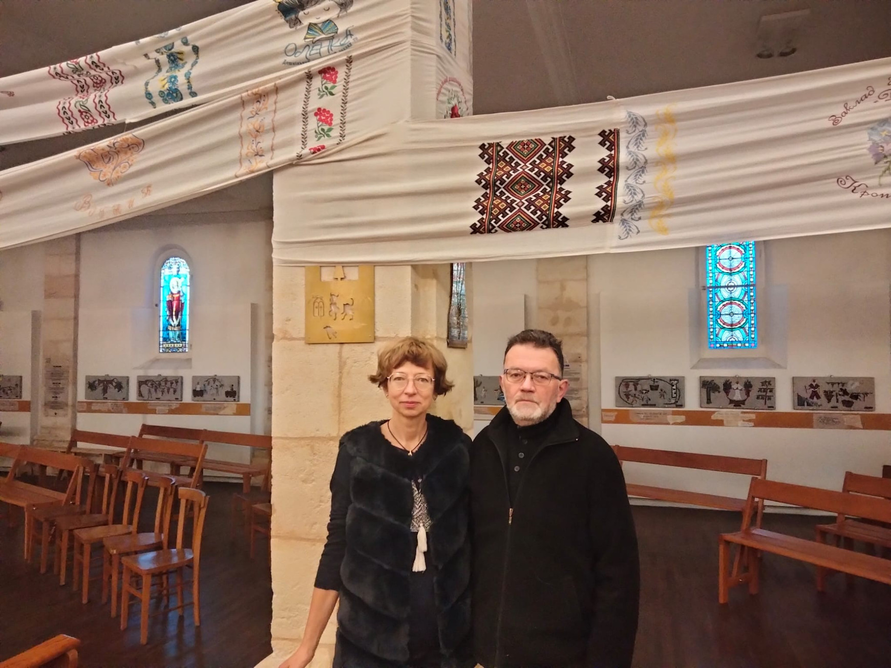 © Cassandre Thomas. Olesya Kuth et son mari sous le rouchnyk de la victoire. Bordeaux, décembre 2025. "Rouchnyk de la victoire" : un fil d’espérance ukrainien traverse Bordeaux