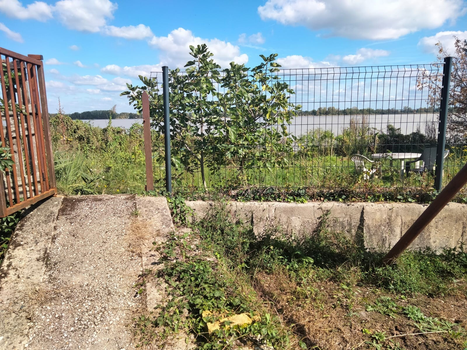 © Cassandre Thomas. La langue de terre derrière le portail est la partie du terrain de Yann et Odile risquant d'être reprise par Bordeaux Métropole. Presqu'île d'Ambès : quand la montée des eaux impactent les habitants