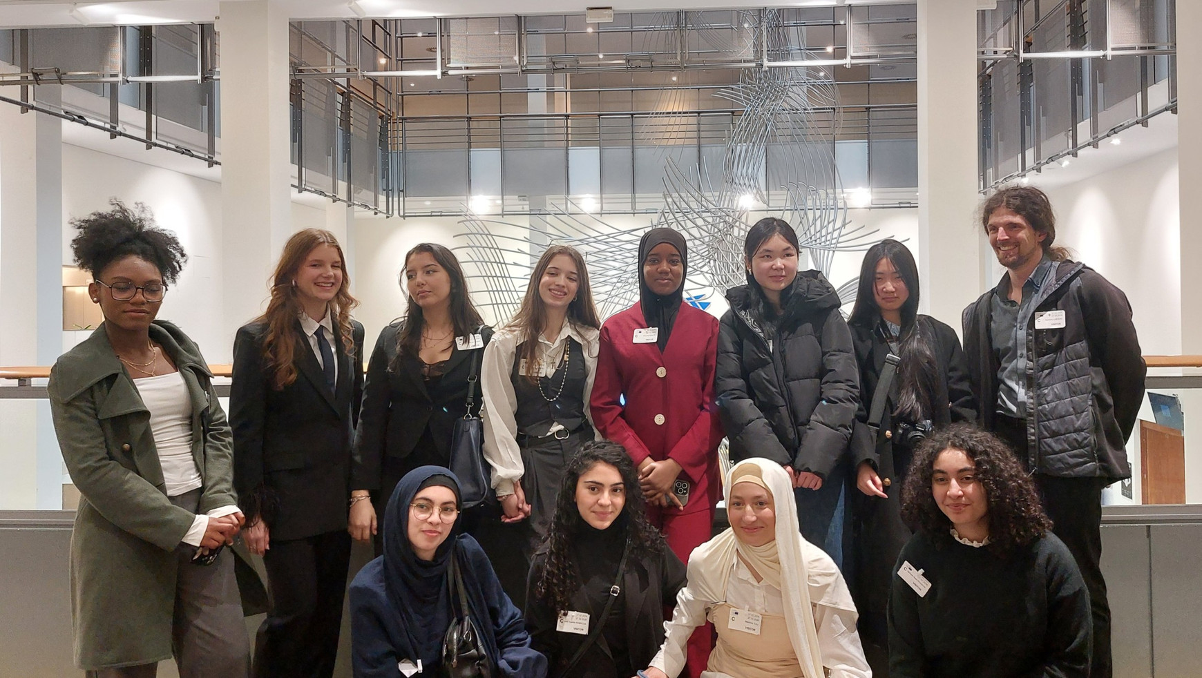 L'association Nouvelles Vagues au Parlement européen. De gauche à droite au premier plan : Wiham, Inès, Meidina, Nafissa, et au second plan : Cyrielle, Adelina, Basma, Pauline, Niouma, Cécile, Loua, et leur accompagnateur Aymeric Labadie. © Pauline Lück Nouvelles Vagues, des filles de Gennevilliers en quête de modèles féministes