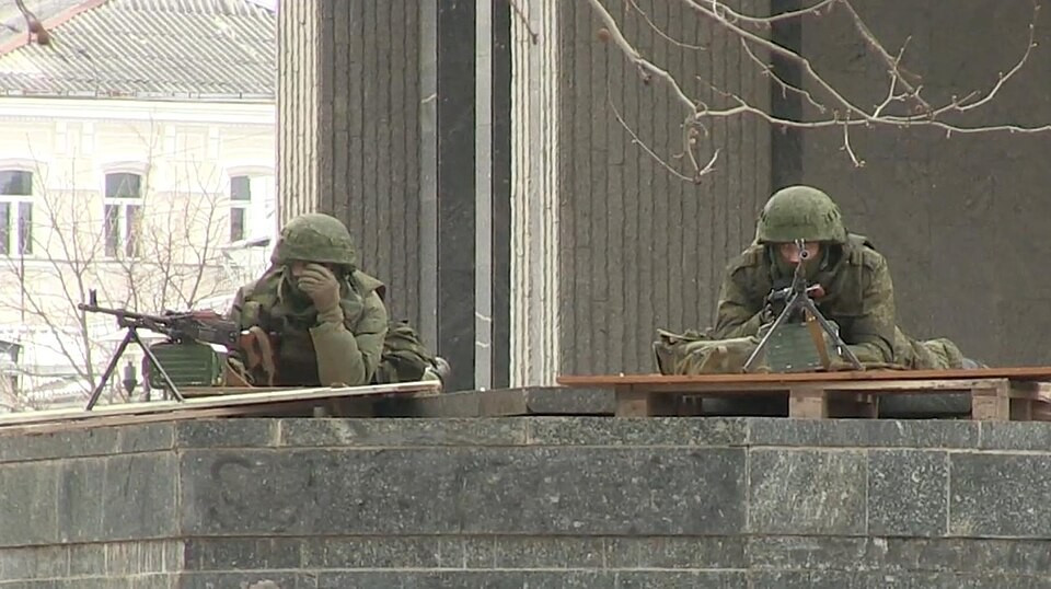 Des "Petits hommes verts" — soldats armés sans insigne —stationnés devant le Parlement à Simferopol tandis que d'autres soldats non identifiés prennent le contrôle des positions stratégiques, le 1er mars 2014. Image fournie par Voice of America. Les Petits hommes verts, le retour