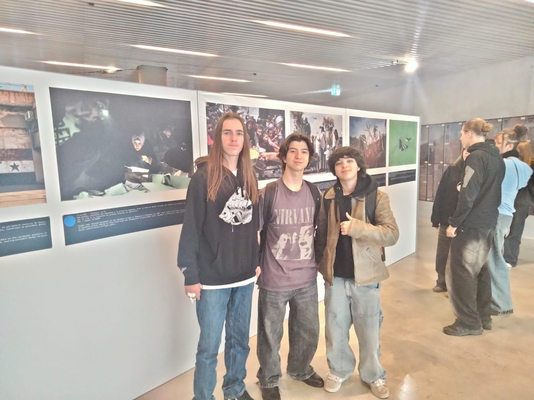 © Cassandre Thomas. Trois élèves en classe de première au lycée Jean Monnet devant l'exposition de l'AFP "Une année grise". Bordeaux, novembre 2025. Tribunes de la presse : des ateliers pour sensibiliser les lycéens à la désinformation