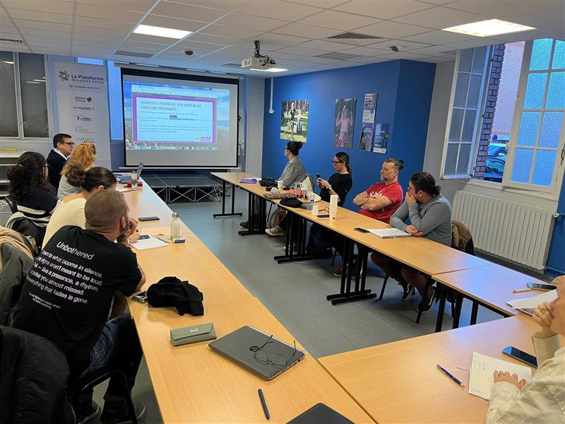 Les membres du Conseil d'administration sont assis et regardent un écran