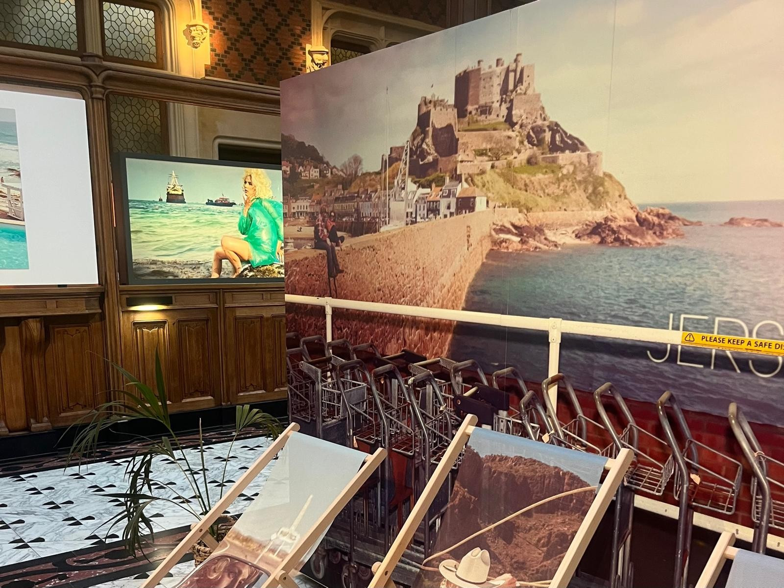 L'exposition met en scène des transats devant un décor ©Louise Cambon Un été culturel et européen à Paris : Le tourisme mondialisé vu par Kourtney Roy à Citéco